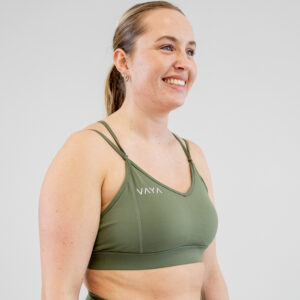 Green VAYA sports bra with thin straps, shown on model from the side